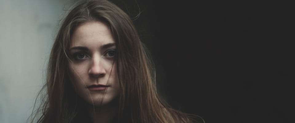 Mädchen mit langem Haar vor einem dunklen Hintergrund